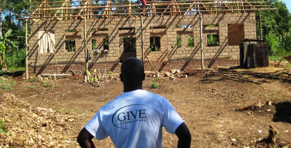 a volunteer watching a building construction in a developing country