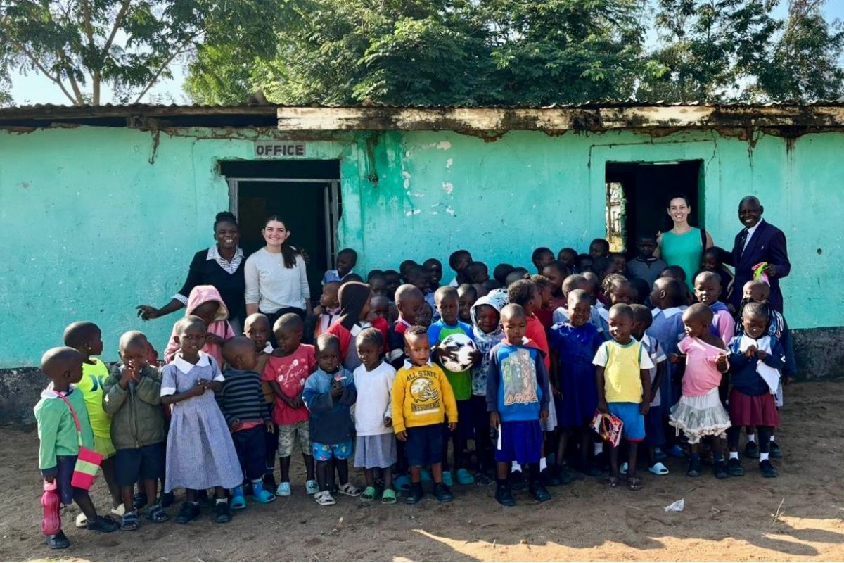 a group of children standing in front of a blue building