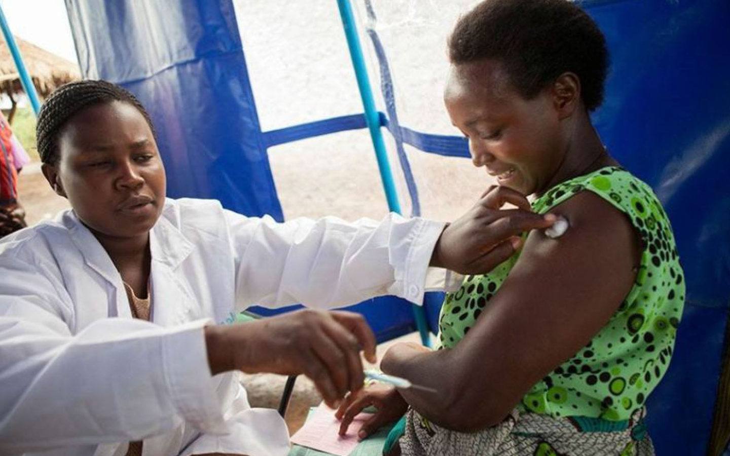 a nurse giving a woman a vaccine shot