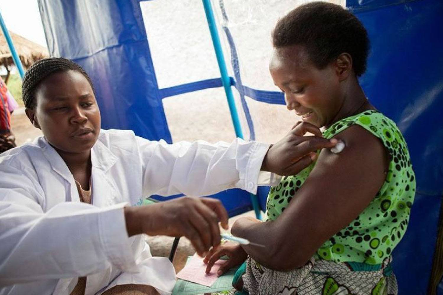 a nurse giving a woman a vaccine shot