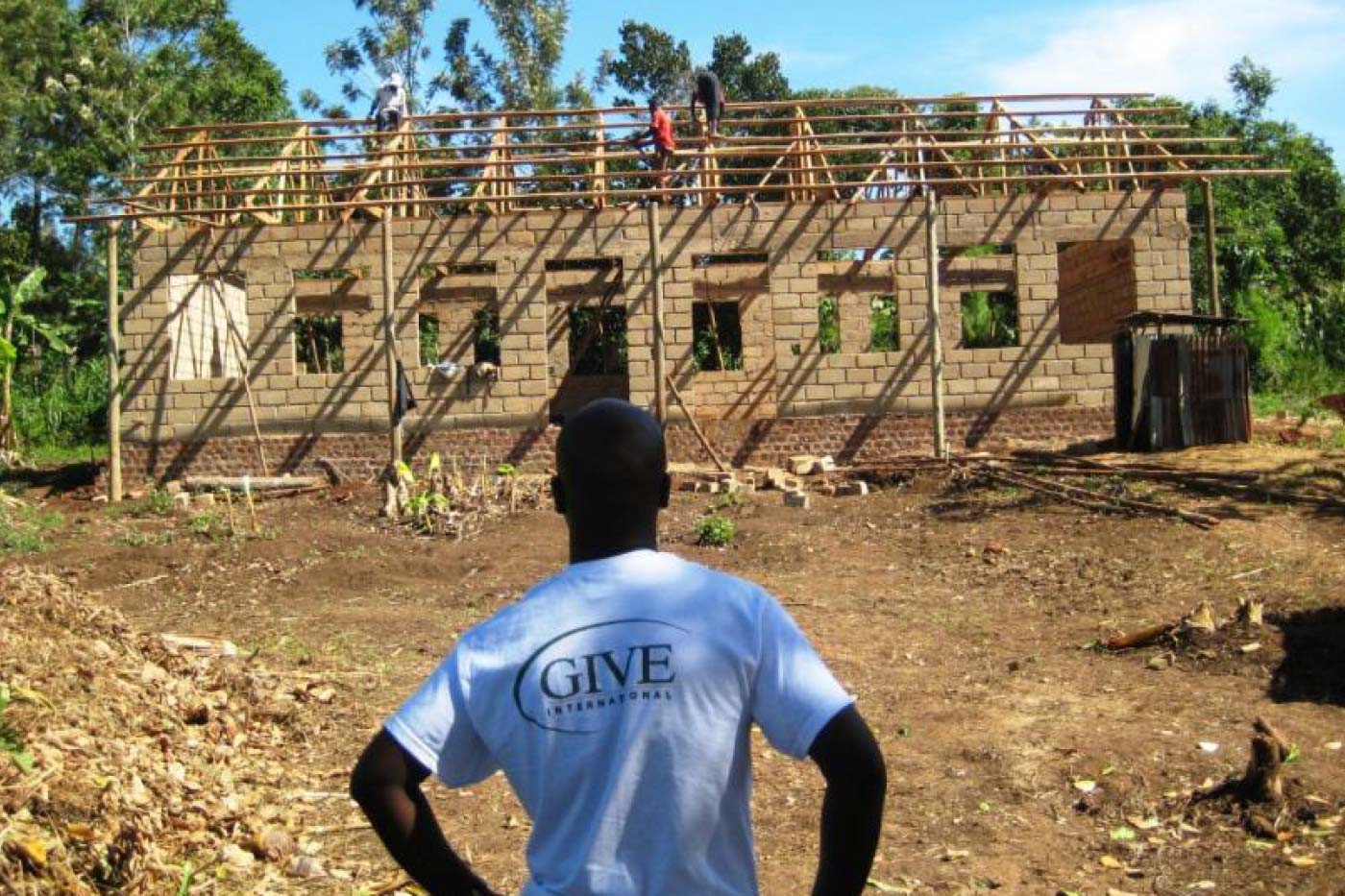 a volunteer watching a building construction in a developing country