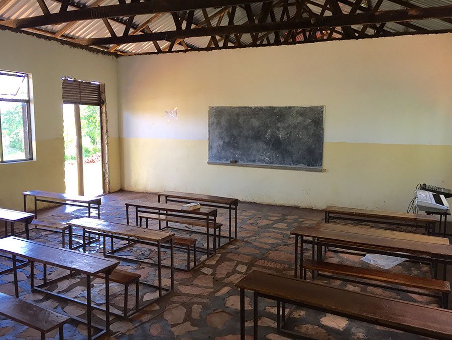 a classroom with desks and chalkboard wall in a developing country