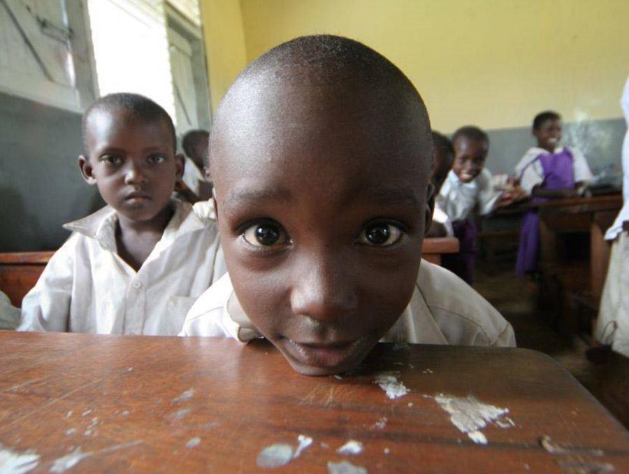 two young boys sitting at their desk in a classroom in a developing country